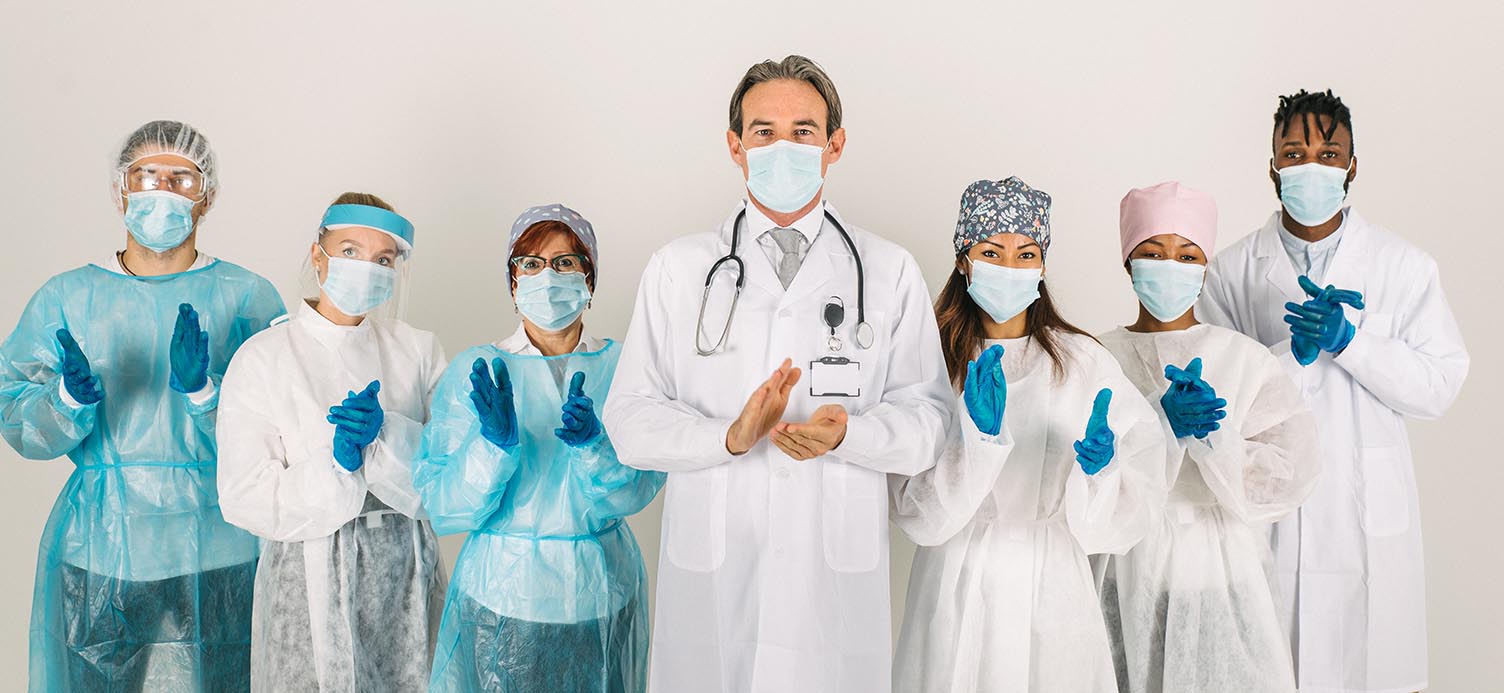 Grupo de profissionais da saúde com mascaras batendo palmas para ilustras as profissoes mais bem pagas nos EUA