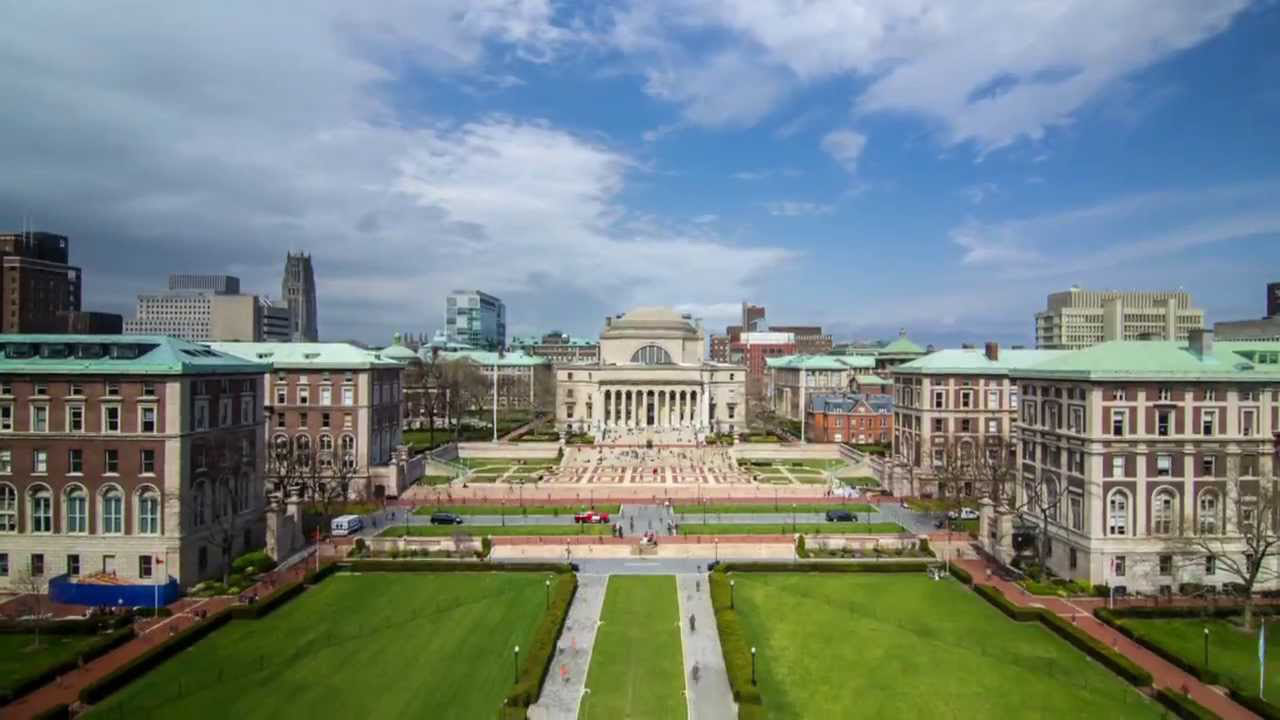 Universidade de Columbia vista de longe com prédios e pessoas passando