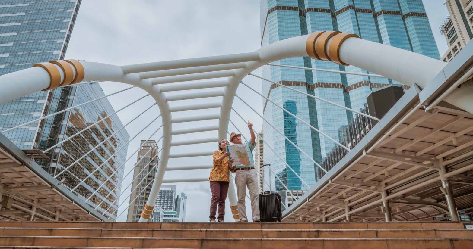 Dois idosos apontando para o horizonte em um ponto turistico